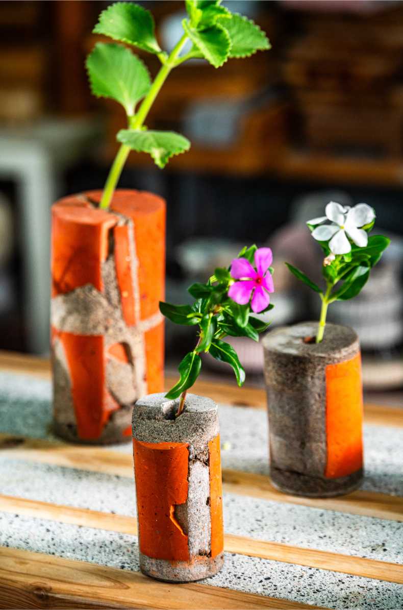 橘色廢磚與再生混凝土花器插著植物